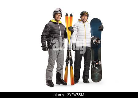 Porträt eines Mannes mit Snowboard und Skiern in voller Länge, der die Kamera isoliert auf weißem Hintergrund betrachtet Stockfoto