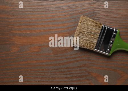 Auftragen von Walnussholz-Beize. Bürste auf Holzoberfläche, Draufsicht. Leerzeichen für Text Stockfoto