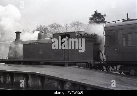 1950er Jahre, historische Dampflokomotive, Nr. 30028 am Bahnhof, wartet auf Abfahrt, Zugführer im Taxi, England, Großbritannien. Stockfoto