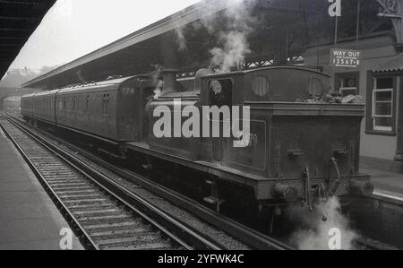 1950er Jahre, historisch, Zugwagen und Dampflokomotive, Nr. 32479 (BR) am Bahnhof, England, Vereinigtes Königreich. Eine Lokomotive der Billinton E4-Klasse, die ursprünglich 1898 für Arbeiten an der London, Brighton and South Coast Railway (LBSCR) und dann an der Southern Railway (SR) gebaut wurde. Auf der neuen British Railway (BR) Post 1948 wurde sie hauptsächlich im Rangierdienst eingesetzt. Sie wurde 1963 außer Dienst gestellt. Stockfoto