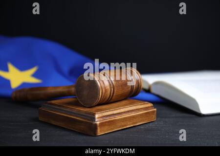 Richter-Hammer, Buch und EU-Flagge auf grauem Tisch vor schwarzem Hintergrund, Nahaufnahme Stockfoto