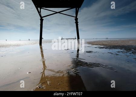 Blick von der viktorianischen Struktur auf Lytham St. Anne's, Blick auf das Meer über den Strand bei sonnigem Wetter. Menschen in der Ferne am Meer. Stockfoto