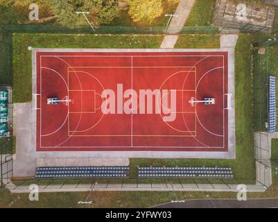 Blick Auf Das Rote Basketballfeld Von Oben. Basketballfeld mit weißen Linien im Freien und Treppen für Zuschauer dahinter Stockfoto