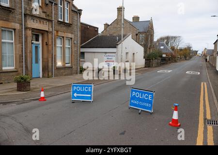 5. Nov. 2024. Castletown, Caithness, Schottland, Großbritannien. Ein Junge auf einem Roller schaut nach, wo die Polizei eine Straßensperrung auf der A836 erzwang. Stockfoto