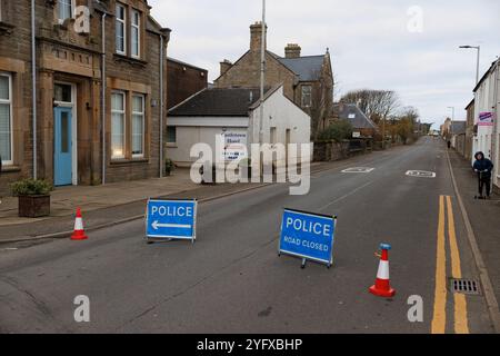 5. Nov. 2024. Castletown, Caithness, Schottland, Großbritannien. Ein Junge auf einem Roller schaut nach, wo die Polizei eine Straßensperrung auf der A836 erzwang. Stockfoto