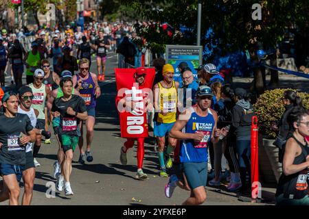 Die Läufer fahren am Sonntag, den 3. November 2024 beim TCS New York City Marathon durch Harlem in New York nahe der 22-km-Marke in der Nähe des Mount Morris Park. 50.000+ Teilnehmer liefen durch die fünf Bezirke und kämpften mit warmem Wetter. (© Richard B. Levine) Stockfoto