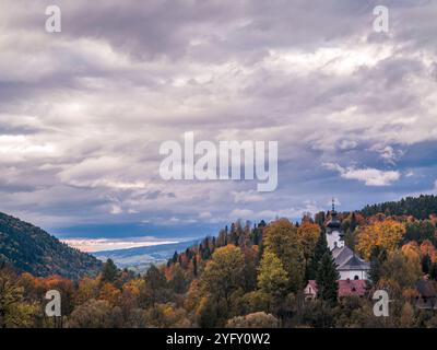 Ein malerischer Panoramablick auf sanfte Hügel und Wälder im Herbst. Das lebhafte Herbstlaub schafft eine bezaubernde Atmosphäre unter einem bewölkten Himmel Stockfoto