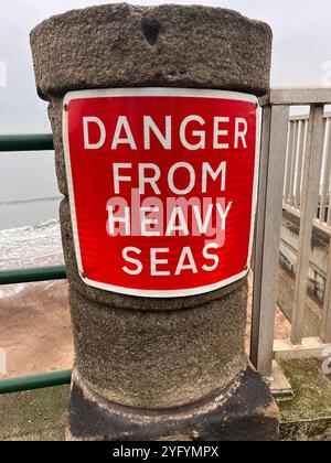 Warnschild "Gefahr durch schwere See" an der Meeresmauer in Sandsend, East Yorkshire, England. Stockfoto