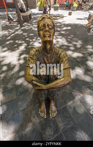 Saragossa, Spanien - 23. Juli 2024 : sitzender Junge mit Blick auf den neuen Turm (Muchacho sentado mirando a la Torre Nueva) Skulptur von Santiago Gimeno Llop. Stockfoto