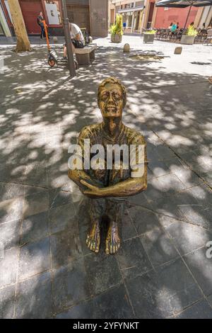 Saragossa, Spanien - 23. Juli 2024 : sitzender Junge mit Blick auf den neuen Turm (Muchacho sentado mirando a la Torre Nueva) Skulptur von Santiago Gimeno Llop. Stockfoto