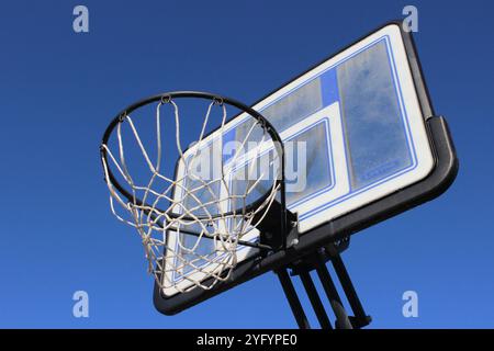 Basketballkorb im Freien vor klarem, blauem Himmel. Stockfoto