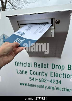 Eine Hand, die einen Wahlzettel in einer Wahlurne in Eugene, Oregon, für die Präsidentschaftswahlen 2024 abgibt. Stockfoto