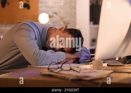 Müder Geschäftsmann, der nachts im Büro schläft Stockfoto