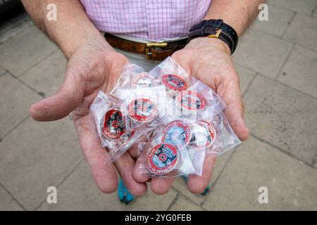 London, Großbritannien. September 2024. Ein Freiwilliger hält eine Handvoll 15 Jahre lang Poppy Cab-Embleme. Poppy Cabs wurde vor 15 Jahren von Londoner Taxifahrern gegründet und bietet Militärveteranen kostenlose Fahrten an, die am jährlichen Gedenktag-Service im Cenotaph in Westminster, London, teilnehmen. Inspiriert vom Royal British LegionÃ-s Poppy Appeal, bei dem rote Mohnabzeichen gegen Spenden ausgetauscht werden, organisieren sich diese engagierten Taxifahrer im Rahmen der Ã¬Poppy CabsÃ® Initiative. Jedes Jahr bieten Fahrer kostenlose Fahrten für Veteranen von den großen Bahnhöfen in ganz L an Stockfoto