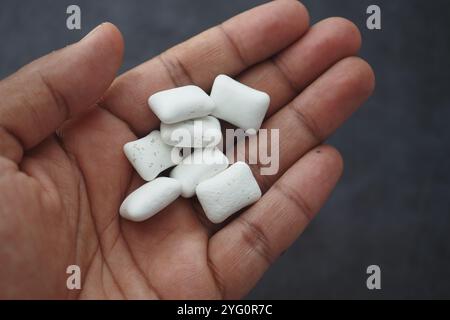 Nahaufnahme der Hand, die weiße Kaugummistücke hält Stockfoto