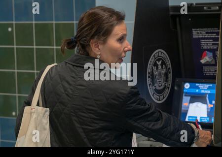 New York, Usa. November 2024. NEW YORK, NEW YORK – 5. NOVEMBER: Eine Frau gibt am National Election Day für die US-Präsidentschaftswahl am 5. November 2024 im Stadtteil Queens in New York City bei der P.S./I.S. 78Q ihren Wahlzettel auf einen Scanner ein. Die Wähler werden zwischen dem republikanischen Präsidentschaftskandidaten, dem ehemaligen Präsidenten Donald Trump, und dem Präsidentschaftskandidaten der Demokraten, Kamala Harris, entscheiden, wer der nächste Präsident der Vereinigten Staaten von Amerika sein wird. Quelle: SOPA Images Limited/Alamy Live News Stockfoto