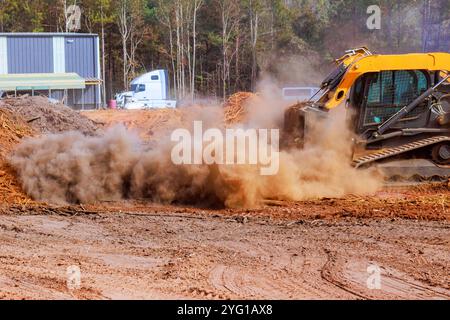 Der kleine Minitraktor für Erdbewegung wird während des Bauens auf ebenem Boden eingesetzt. Stockfoto