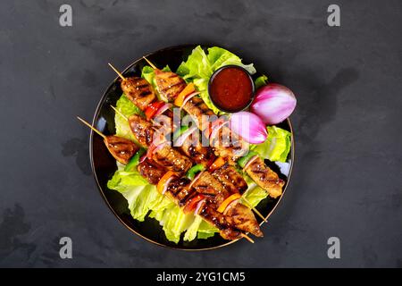 Schaschlik auf Spieß auf hölzernem Hintergrund. Stockfoto