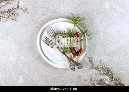 Weihnachtliche weiße Tischdekoration mit Zweigverzierung. Stockfoto