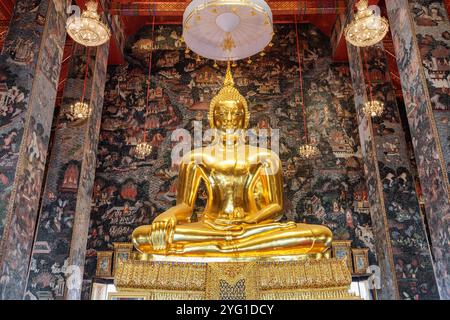 Fantastischer Blick auf die vergoldete Buddha-Statue zwischen erstaunlichen Wandmalereien Stockfoto