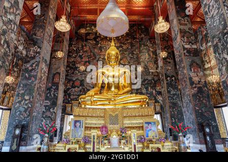 Fantastischer Blick auf die vergoldete Buddha-Statue zwischen erstaunlichen Wandmalereien Stockfoto