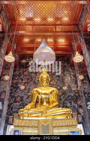 Fantastischer Blick auf die vergoldete Buddha-Statue zwischen erstaunlichen Wandmalereien Stockfoto