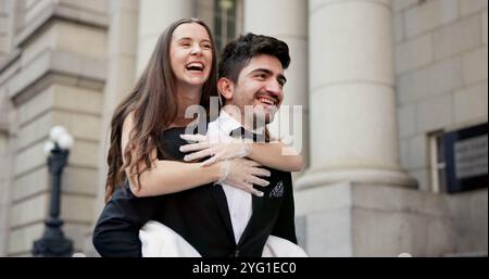 Happy, Pärchen und Huckepack im Freien für Hochzeitsfeiern, Heirat und Engagement. Lächeln, Menschen und Liebe mit Liebe zur Partnerschaft Stockfoto