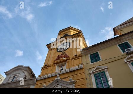 Uhrenturm, ein prominentes Denkmal in der Korzo-Straße im Zentrum von Rijeka, Kroatien. Der Uhrenturm mit seiner markanten gelben Fassade Stockfoto