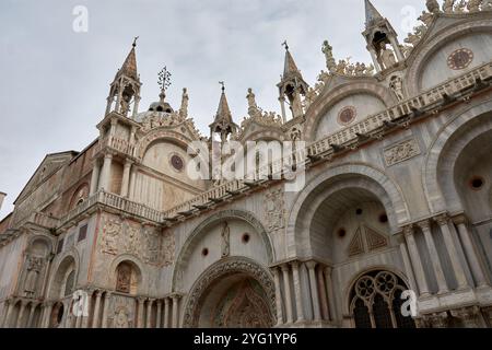 Nahaufnahme der kunstvollen Fassade des Markusdoms in Venedig, Italien. Dieses ikonische byzantinische Meisterwerk zeigt komplexe Goldmosaiken, Stockfoto