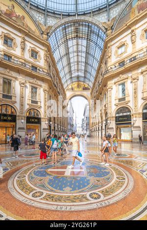 MAILAND, ITALIEN - 18. JULI 2023: Besucher schlendern durch die atemberaubende Galleria Vittorio Emanuele II in Mailand, bewundern elegante Architektur und komplexe Mosaiken und genießen eine lebhafte Atmosphäre Stockfoto