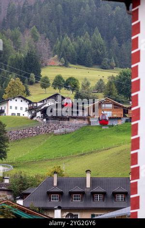 St. Ulrich, Italien Sommerblick im alpinen Dorf in den Dolomiten mit den roten Hütten und Häusern der Bergbahn Mont Seuc Stockfoto