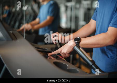 Nahaufnahme des Fingers, der die Starttaste auf dem Laufband beim Fitness-Studio drückt Stockfoto