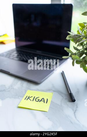 Hängen Sie es mit dem Wort ikigai auf einen Schreibtisch mit Laptop. Zweck des Lebens. Persönliches Wachstum Stockfoto