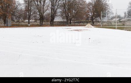 Leeres Stadion, Laufband, gepflastert, mit Markierungen für Läufer. Wintersport bei schneebedecktem Wetter Stockfoto