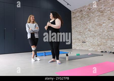 Zwei Frauen stehen und reden im Fitnessstudio Stockfoto