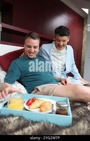 Männer, die im Bett frühstücken Stockfoto