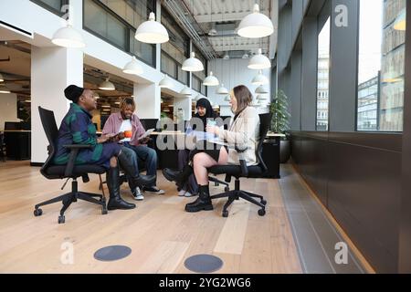 Verschiedene Gruppen von Geschäftsleuten, die im Büro diskutieren Stockfoto
