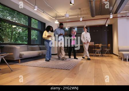 Verschiedene Gruppen von Geschäftsleuten, die durch das Büro laufen Stockfoto
