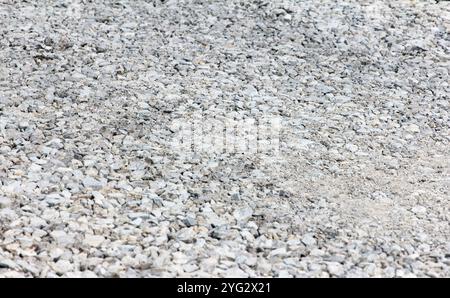 Kies aus großen Fraktionen, Steinbrüche, Bausteine aus Zuschlagsteinen. Nahaufnahmen von zerquetschten Steinen liegen auf dem Boden. Breakstone. Granitkies Stockfoto