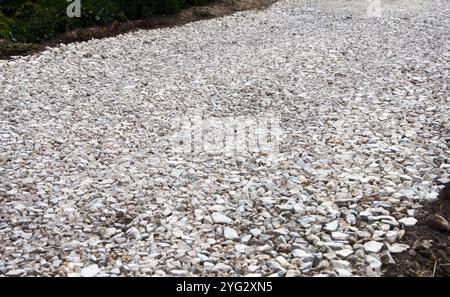 Es wird daran gearbeitet, eine neue Straße zu bauen und zu legen. Crushed Stone Close-up liegt auf dem Boden. Bruchstein. Stockfoto