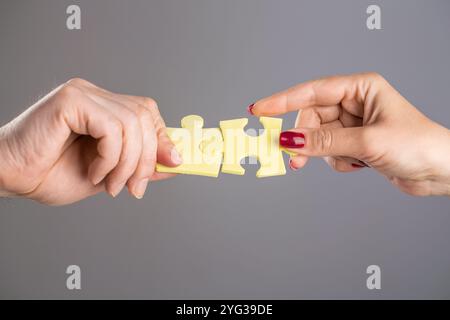 Puzzles. Mann und Frau halten ein Puzzle in der Hand. Geschäftslösungen, Erfolg und Strategiekonzept. Die Hände verbinden Puzzle. Hand des Mannes und Stockfoto