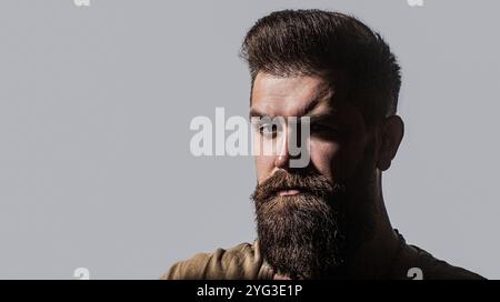 Seite vor dem Porträt eines stilvollen jungen Mannes. Perfekter Bart. Nahaufnahme eines jungen bärtigen Mannes, stilvolle Frisur, Bart. Seitlicher bärtiger Mann isoliert Stockfoto