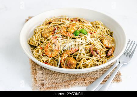 Basilikum-Pesto-Pasta mit Garnelen garniert mit frischen Basilikumblättern Low Angle Nahaufnahme Foto Stockfoto