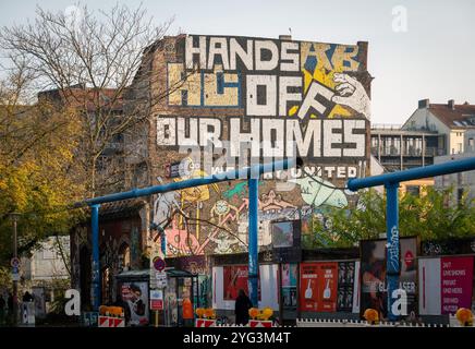 Berlin, Deutschland. November 2024. Die Worte „Hände weg von unseren Häusern“ stehen auf der Fassade eines ehemals besetzten Hauses in der Köpenicker Straße im Bereich der Hausnummern 130 bis 140. Das Landgericht Berlin verhandelt die Räumung eines ehemals besetzten Hauses in der Köpenicker Straße 137. Quelle: Soeren Stache/dpa/Alamy Live News Stockfoto