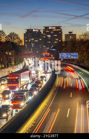 Abendverkehr, teilweise mit Staus, langsam fahrender Verkehr auf der Autobahn A40, Essener Skyline, Evonik Group Hauptsitz, Essen, Nordrhein-Westp Stockfoto