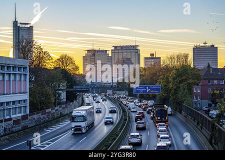 Abendverkehr, teilweise mit Staus, langsam fahrender Verkehr auf der Autobahn A40, Skyline von Essen, RWE-Turm links, Evonik-Konzernzentrale Stockfoto