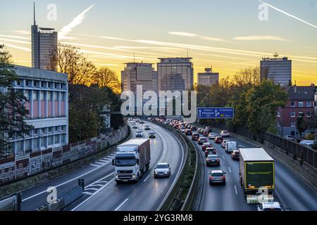 Abendverkehr, teilweise mit Staus, langsam fahrender Verkehr auf der Autobahn A40, Skyline von Essen, RWE-Turm links, Evonik-Konzernzentrale Stockfoto