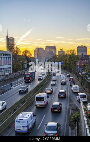 Abendverkehr, teilweise mit Staus, langsam fahrender Verkehr auf der Autobahn A40, Skyline von Essen, RWE-Turm links, Evonik-Konzernzentrale Stockfoto