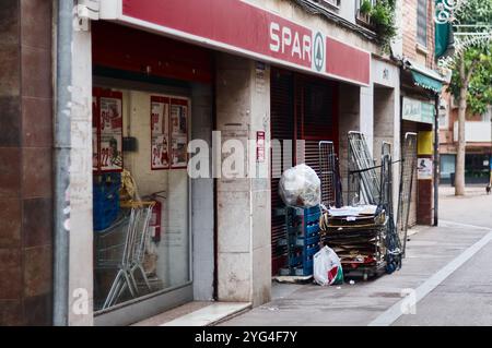 Viladecans. Spanien - 03. November 2024: Spar Supermarkt geöffnet mit einem roten Schild. Pappkartons und Trolleys sind ordentlich im Freien gestapelt, kreati Stockfoto