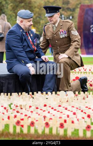 Eröffnung des Gedenkmohnfeldes am National Memorial Arboretum im November 2024. Mohnblumen wurden auf dem Feld platziert, um an die Verstorbenen in den Weltkriegen und Konflikten zu erinnern. Während der Gedenkfeier fanden zwei Mitglieder der Gruppe „Talent in the Ranks“ statt, Lee Wright (ein Gedicht vorlesen) und Michael Lauchlan (ein Lied vorführen). Im Bild halten Michael und Lee für einen Moment der Reflexion inne Stockfoto